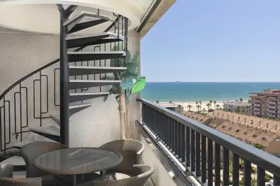 a balcony with a table and chairs and the ocean at ApartUP Patacona Sunrise Duplex II in Valencia