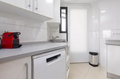 a white kitchen with a sink and a dishwasher at ApartUP Patacona Sunrise Duplex II in Valencia