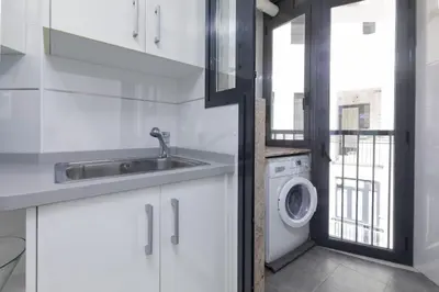 a kitchen with a sink and a washing machine at ApartUP Patacona Sunrise Duplex II in Valencia