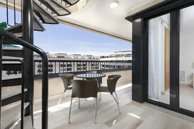 a balcony with a table and chairs and a view of the city at ApartUP Patacona Sunrise Duplex II in Valencia