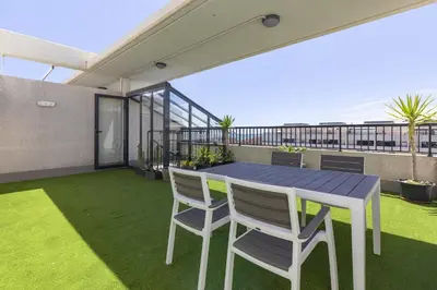a patio with a table and chairs on a balcony at ApartUP Patacona Sunrise Duplex II in Valencia