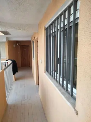 an empty hallway of a building with windows at Acogedor Apartamento Cullera 200 metros playa in Cullera