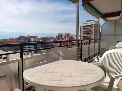 a white table and chairs on a balcony at Acogedor Apartamento Cullera 200 metros playa in Cullera