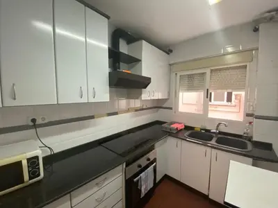 a kitchen with white cabinets and a sink and a microwave at Family flat zona Aragon close to city center and beach in Valencia