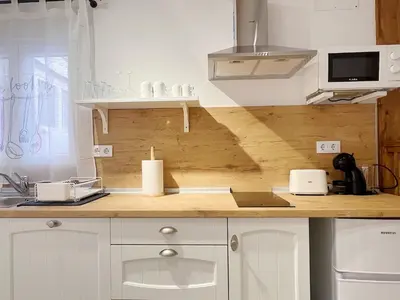 a kitchen with white cabinets and a wooden counter top at Encantador apartamento vigas de madera in Valencia