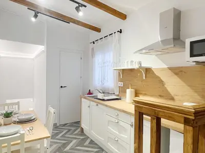 a kitchen with a wooden counter top and a table at Encantador apartamento vigas de madera in Valencia