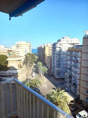 a balcony view of a city with palm trees and buildings at Victoria, 8-22 in Cullera