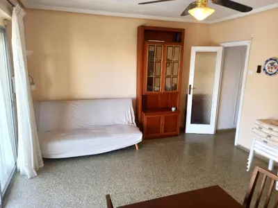 a living room with a white couch and a wooden cabinet at Victoria, 8-22 in Cullera
