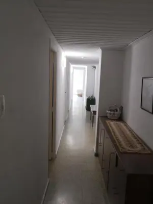 a hallway of a room with white walls and a long hallway at Victoria, 8-22 in Cullera