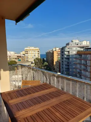 a balcony with a wooden table and chairs on a building at Victoria, 8-22 in Cullera