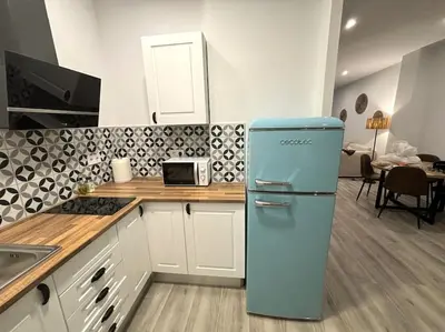 a kitchen with a blue refrigerator in a room at Precioso apartamento en la playa in Valencia