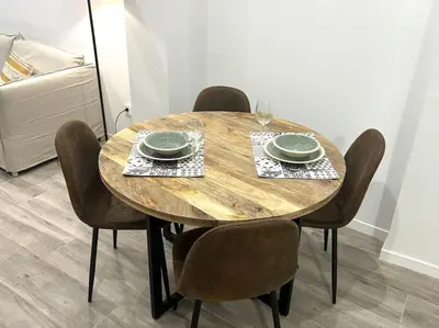 a wooden table with chairs and plates and wine glasses at Precioso apartamento en la playa in Valencia