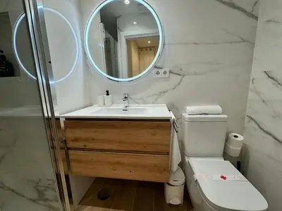 a bathroom with a sink and a mirror and a toilet at Como en casa in Puerto de Sagunto