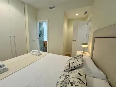 a bedroom with a large white bed with a window at Como en casa in Puerto de Sagunto