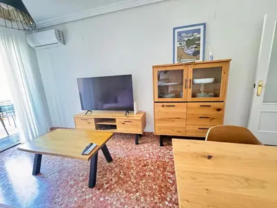 a living room with a tv and a wooden entertainment center at Vacaciones en el mar in Puerto de Sagunto
