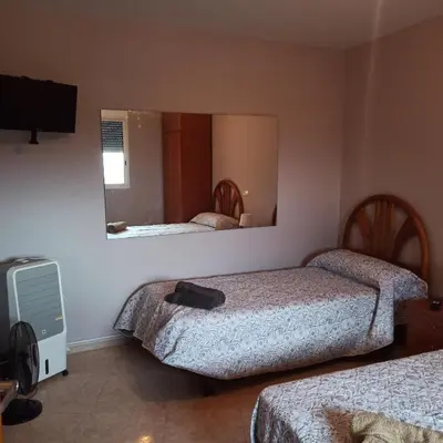 a hotel room with two beds and a mirror at Casa Sol y montaña-habitaciones in Torrent