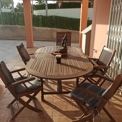 a wooden table and chairs on a patio at Casa Sol y montaña-habitaciones in Torrent