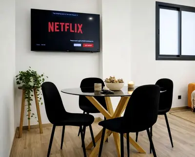a table and chairs with a television on a wall at Avakian Valencia Centro in Valencia