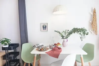 a white dining room table with green chairs at RC - Modern Valencia loft in Valencia
