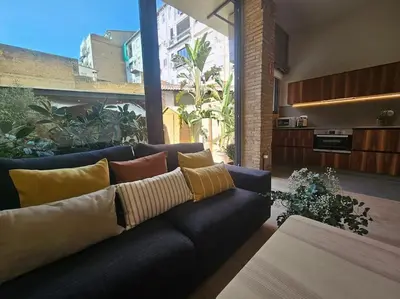 a living room with a blue couch with pillows at Tradicional Casa con patio Ruzafa in Valencia