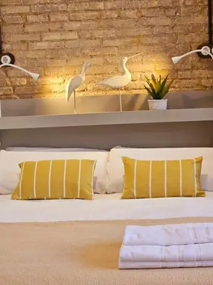 a bedroom with a bed with yellow pillows and birds at Tradicional Casa con patio Ruzafa in Valencia