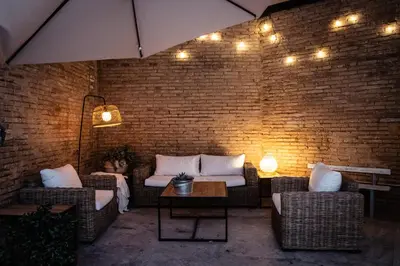a patio with couches and a brick wall with lights at Tradicional Casa con patio Ruzafa in Valencia