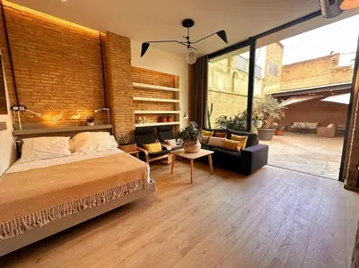 a bedroom with a large bed and a living room at Tradicional Casa con patio Ruzafa in Valencia