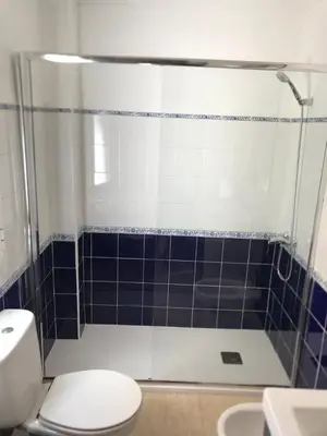 a bathroom with a toilet and a shower with blue tiles at El balcón de Alexia, 5 minutos del aeropuerto in Partida de La Cañada
