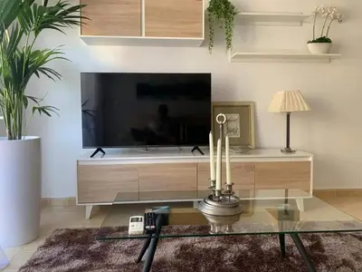 a living room with a tv and a glass table at El balcón de Alexia, 5 minutos del aeropuerto in Partida de La Cañada