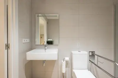 a bathroom with a sink and a toilet and a mirror at 2 rooms 4 Pax, new flat, wifi AC in Valencia