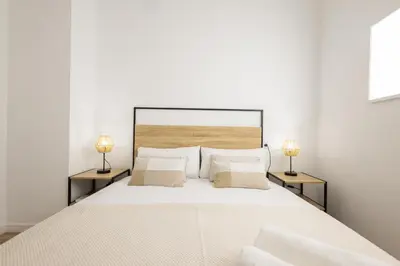 a white bedroom with a large bed with two lamps at 2 rooms 4 Pax, new flat, wifi AC in Valencia