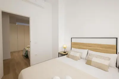 a white bedroom with a large white bed with pillows at 2 rooms 4 Pax, new flat, wifi AC in Valencia