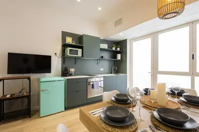 a kitchen and dining room with a table and a television at 2 rooms 4 Pax, new flat, wifi AC in Valencia