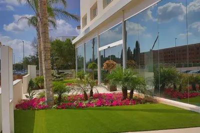 a building with a garden of flowers in front of it at SH Campus Lyceum in Moncada
