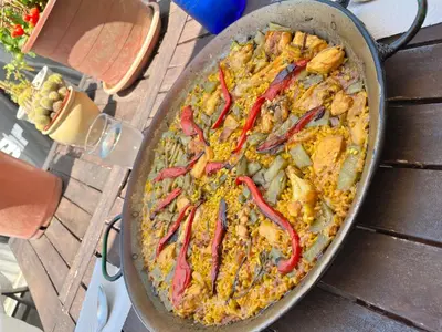 a pan filled with food on a wooden table at Cerca del mar, ascensor, descuentos semanales 4 personas in Cullera