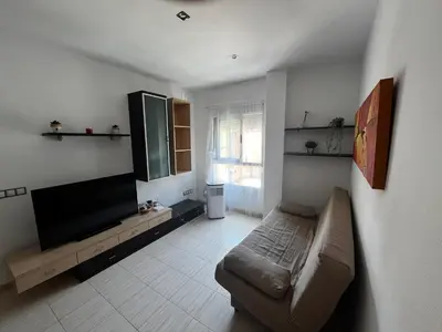 a living room with a couch and a flat screen tv at Cerca del mar, ascensor, descuentos semanales 4 personas in Cullera
