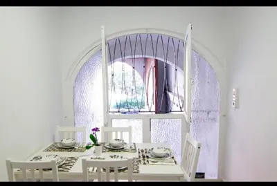 a white dining room with a white table and chairs at El Parterre Apartamento in Valencia
