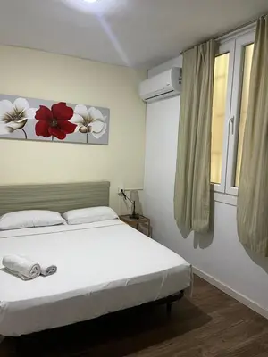 a bedroom with a white bed and a window at El Parterre Apartamento in Valencia