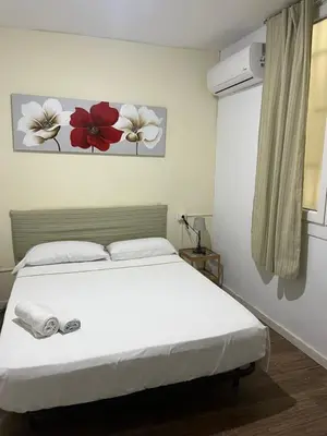 a bedroom with a white bed and flowers on the wall at El Parterre Apartamento in Valencia