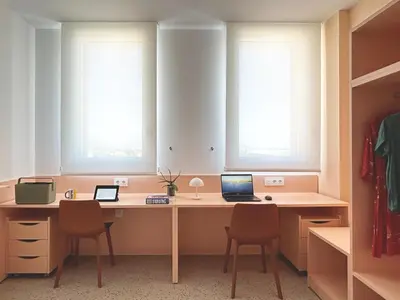 a bedroom with a bed and a desk with a laptop at Valencia Tower in Burjasot
