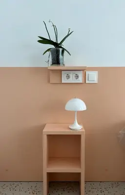 a table with a lamp and a plant on a wall at Valencia Tower in Burjasot