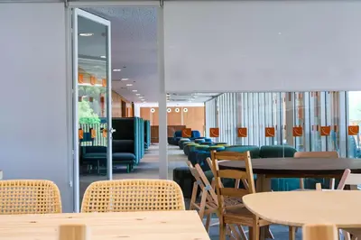 a dining room with tables and chairs and windows at Valencia Tower in Burjasot
