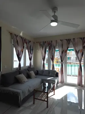 a living room with wooden cabinets and a tv at Sea view apartment in Cullera