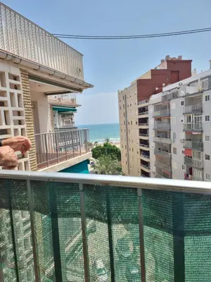 a bedroom with a large bed with a wooden door at Sea view apartment in Cullera