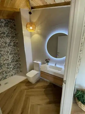 a bathroom with a toilet and a sink and a mirror at Garage House in Calles