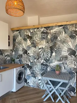 a kitchen with a wall with a mural of plants at Garage House in Calles