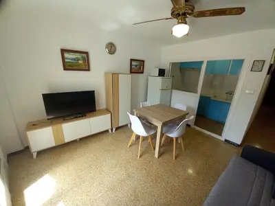 a living room with a dining room table and a television at Amanecer, 1-2 in Cullera