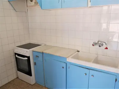 a small kitchen with blue cabinets and a sink at Amanecer, 1-2 in Cullera