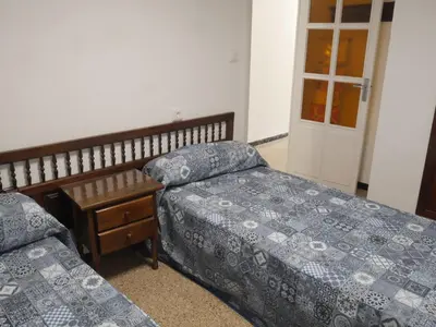 a bedroom with two beds and a window and a door at Amanecer, 1-2 in Cullera