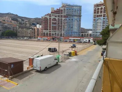 a white van parked on a street with tall buildings at Amanecer, 1-2 in Cullera